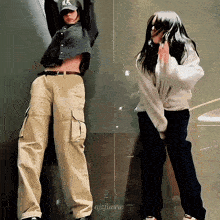 two women are standing next to each other and one has a hat with the letter l on it