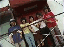 a group of people are posing for a picture and one of them is wearing a shirt that says ' abercrombie ' on it