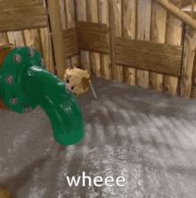 a green pipe is coming out of a wooden wall and the word wheee is on the bottom of the picture