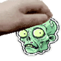 a hand is holding a cartoon drawing of a zombie 's head .