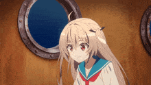 a girl in a sailor uniform is smiling in front of a round window