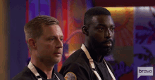 two men are standing next to each other with a bravo logo in the corner