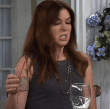 a woman holding a glass of water with a straw