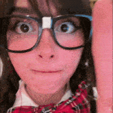a girl wearing glasses and a plaid bow tie is making a face