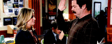 a man is giving a high five to a woman in an office
