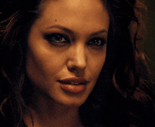 a close up of a woman 's face with a very dark background