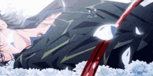 a man in a suit is laying in a bed of flowers with a red sword in his hand .