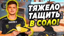 a man in a black and yellow ggbet shirt holds a gold plaque