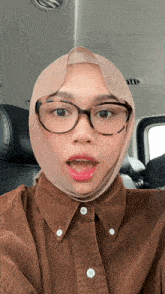 a woman wearing glasses and a hijab has her mouth open