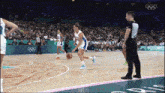 a basketball game is being played at the olympics and a referee is watching