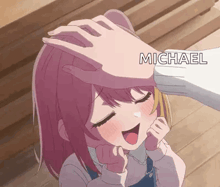 a person is petting a little girl 's head with the name michael written on it .