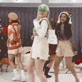a woman wearing a green mask is dancing with two other girls