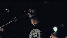 a man is singing into a microphone while holding a guitar