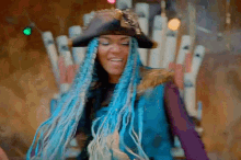 a woman with blue braids is wearing a pirate hat and a blue vest .