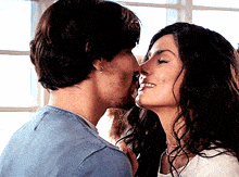 a man kissing a woman on the forehead while she smiles
