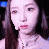 a close up of a woman 's face with a microphone around her neck