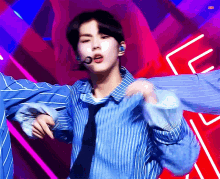 a man wearing a blue striped shirt and tie is dancing