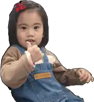 a little girl giving a thumbs up wearing overalls and a shirt that says hanscups
