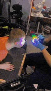 a person wearing blue gloves is holding a cube in front of a child 's eye