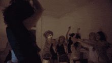 a group of people are dancing in a dark room