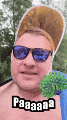 a man wearing sunglasses and a hat with a peacock on his chest says paaaaa
