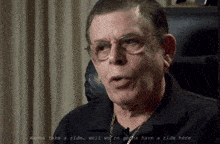 a man wearing glasses and a black shirt says " wanna take a ride "