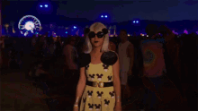 a woman wearing mickey mouse ears sunglasses and a yellow shirt