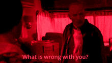 a man in a red room with the words " what is wrong with you " below him