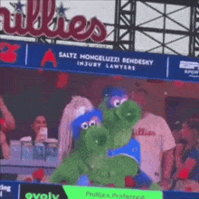 a phillies mascot is standing in front of a sign for saltz mongeluzzi bendesky injury lawyers