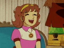 a girl in a pink dress with a gold star necklace is laughing
