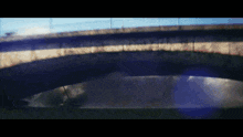 a bridge over a body of water with a blue light shining through it