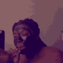 a woman is wearing a black mask on her face while taking a selfie .