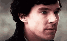 a close up of a man 's face with a slight smirk on his face .