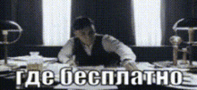 a man is sitting at a desk with the words " где бесплатно " written on the screen