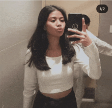 a woman taking a picture of herself in the mirror with a smiley face on it