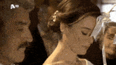 a woman in a wedding dress stands next to a man with a hd logo on the bottom