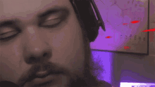 a man wearing headphones looks at the camera in front of a poster that says " coffee "