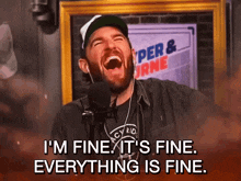 a man is laughing in front of a microphone with the words " i 'm fine it 's fine everything is fine "