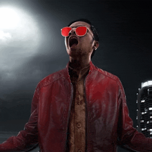 a man in a red leather jacket and red sunglasses screams