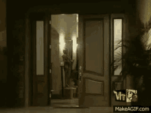 a woman in a black dress is standing in a doorway with a vh1 logo behind her