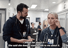 a man and a woman are talking in a hospital hallway and the woman says she does n't want to talk to me