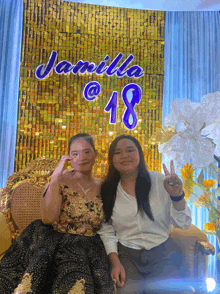 two girls posing in front of a wall that says jamila @ 18