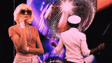 two people are standing in front of a disco ball