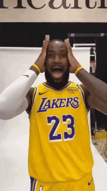 a basketball player wearing a yellow lakers jersey