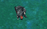 a person is standing in the water with a red ribbon coming out of the water