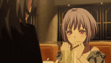 a girl with purple hair and red eyes is sitting at a table with a man
