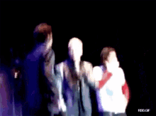 a blurry picture of three men on a stage with rbd.gif written below them