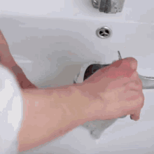 a person is cleaning a toothbrush in a sink
