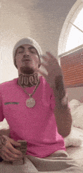 a man wearing a pink shirt and a beanie is holding money