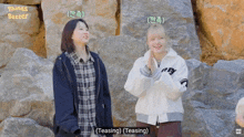 two girls are standing next to each other and one of them is wearing a teasing jacket